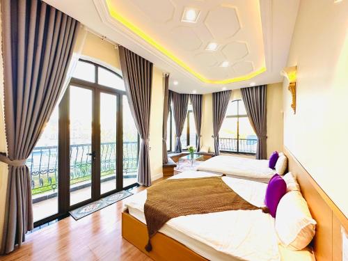 1 Schlafzimmer mit 2 Betten und großen Fenstern in der Unterkunft Adalia Villa & Hotel Đà Lạt in Da Lat
