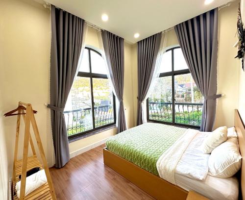 - une chambre avec un lit et 2 grandes fenêtres dans l'établissement Adalia Villa & Hotel Đà Lạt, à Đà Lạt