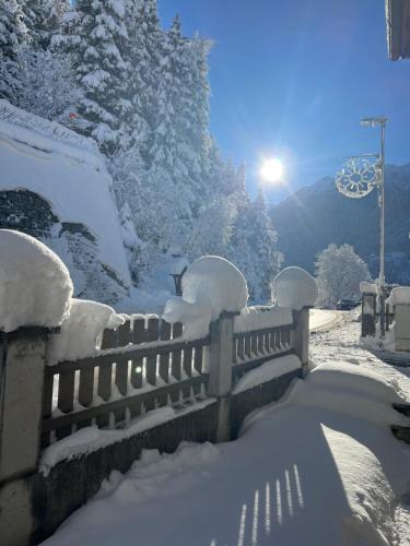 une clôture recouverte de neige avec le soleil en arrière-plan dans l'établissement Gschlössle Ferienwohnungen, à Jerzens