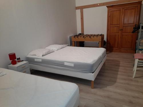 een slaapkamer met 2 bedden en een houten kast bij location petit gite individuel in Orgères