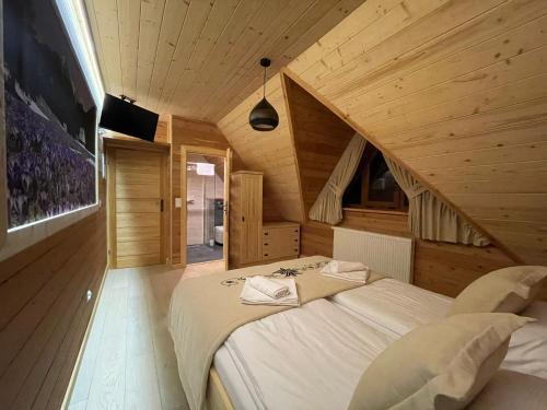 a bedroom with a large bed in a wooden room at Stella Haus in Dzianisz