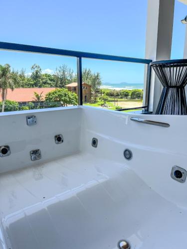 a white bath tub in a room with a window at Gamboa Luna y Sol Apart-Hotel in Gamboa