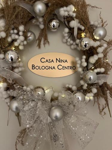 Casa Nina Bologna Centro في بولونيا: إكليل عيد الميلاد مع لافتة تقرأ csa kmina bolota