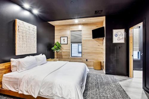 a bedroom with a white bed and a black wall at Nova Rooftop Villa in New Orleans