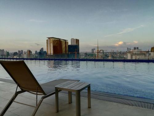 a chair sitting on the edge of a swimming pool at City View Studio in Phnom Penh
