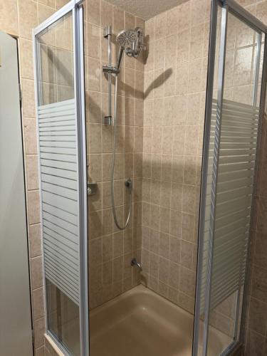 een douche met een glazen deur in de badkamer bij Wohnung mit Küche, Fernseher, WLAN und Parkplatz - Brian in Werne an der Lippe