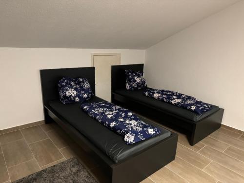 two black couches with blue pillows in a room at Wohnung mit Küche, Fernseher, WLAN und Parkplatz - Brian in Werne an der Lippe
