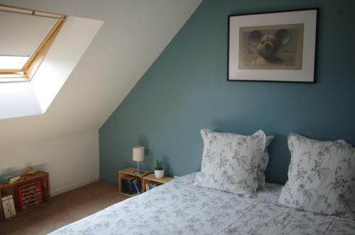 - une chambre dotée d'un lit avec un mur bleu dans l'établissement Charmante Maison de Pêcheur en baie du Mont Saint Michel, à Genêts