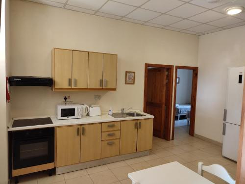 a kitchen with a sink and a microwave at SC Club Village in Pembroke 