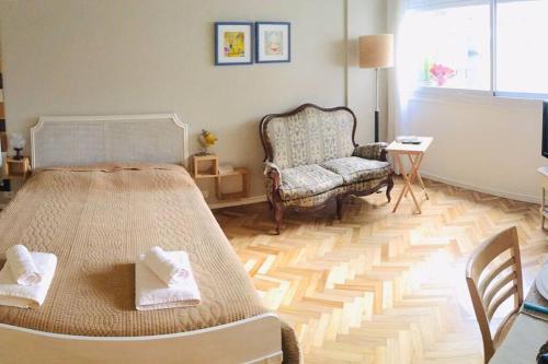 a bedroom with a large bed and a chair at Tu Paraíso Urbano in Buenos Aires