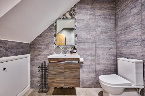 a bathroom with a toilet and a mirror at Portstewart Central Loft Apartment in Portstewart