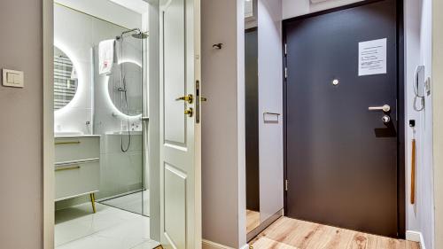 a bathroom with a shower and a blue door at Rezydencja Niechorze 124 - 5D Apartamenty in Niechorze