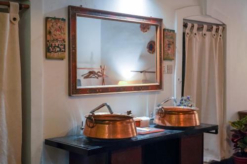 deux pots en cuivre sur une table avec miroir dans l'établissement Samsara Apartments by Baber Mahal Revisited, à Katmandou