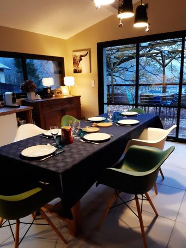 Le Schuss في آكس ليه تيرم: غرفة طعام مع طاولة سوداء وكراسي