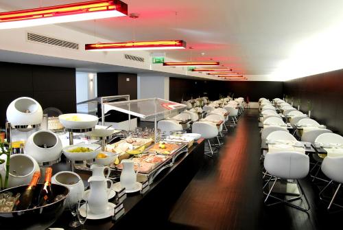 a buffet line of tables with white chairs and food at Hotel Jeronimos 8 in Lisbon