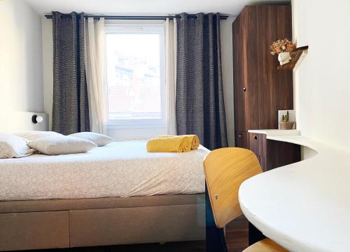 a bedroom with a bed with a window at Le petit Berriat - Grenoble centre in Grenoble