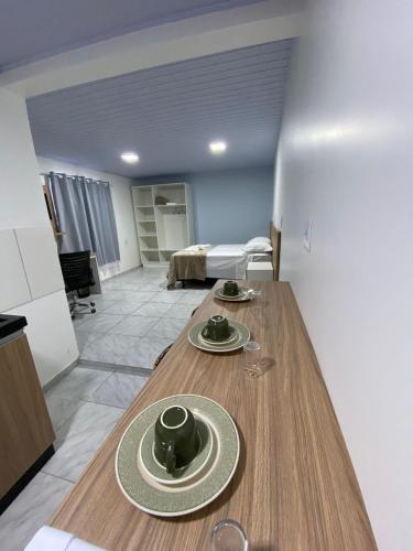 a kitchen with a wooden table with plates on it at Pousada Route 58 in Gravataí