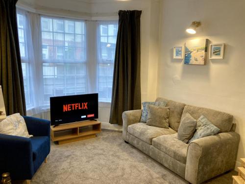 a living room with a couch and a tv at Fairfax in Southend-on-Sea
