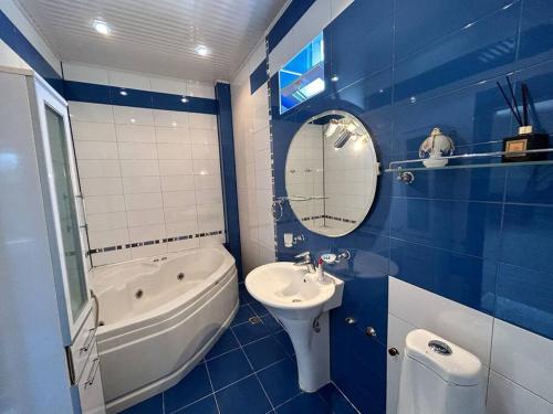 a blue and white bathroom with a sink and a bath tub at Relax in eco-best zone of Baku in Baku