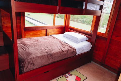 ein kleines Schlafzimmer mit einem Etagenbett und zwei Fenstern in der Unterkunft Hostería Molino de Café 