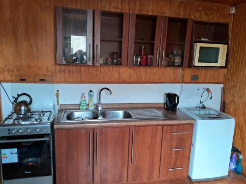a kitchen with a sink and a microwave at Casa Independiente Ciudad de Chonchi in Chonchi