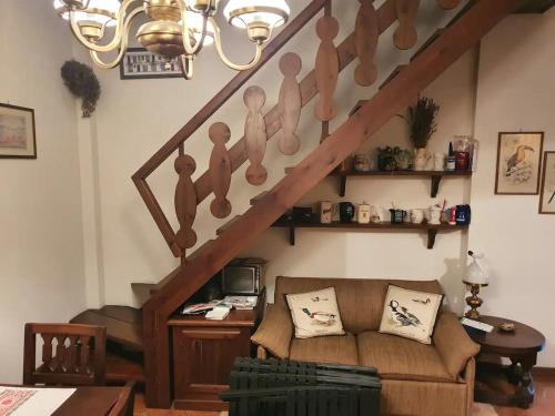 a living room with a couch and a staircase at Appartamento Belvedere in Frabosa Soprana