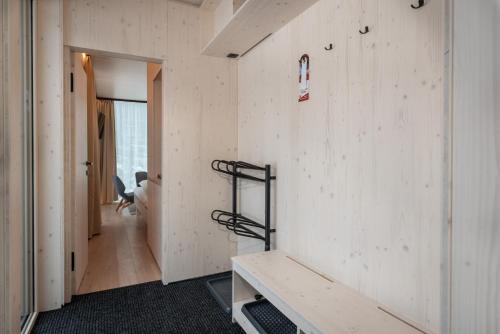 a room with a white wall with a bench in it at Hotel Björnson & Björnson TREE HOUSES Jasná in Demanovska Dolina