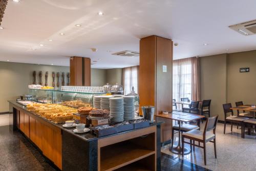 a bakery with a display case with pastries on it at DELPLAZA Marabá São Paulo in Sao Paulo