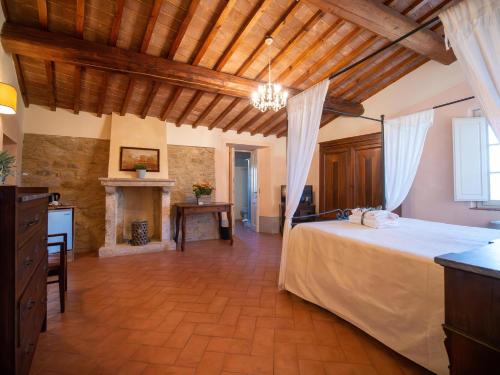 1 dormitorio grande con 1 cama y chimenea en Locanda Le Giunche, en Guardistallo