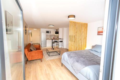 une chambre avec un lit et un salon dans l'établissement KASA GLORIA - Tout équipé - Place parking privée - WIFI, à Saint-Quentin