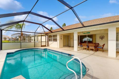 a swimming pool with a patio and a house at Buttercream Villa in Biggar