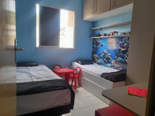 a small room with two beds and a window at Apartamento confortável e sofisticado em Aracaju in Aracaju