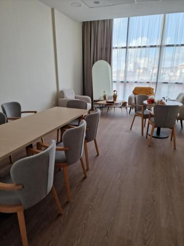 einen Konferenzraum mit Tischen, Stühlen und Fenstern in der Unterkunft Zenao Appart'hôtels Boulogne-sur-Mer - La Rose des Vents in Boulogne-sur-Mer