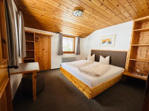 Bett in einem Zimmer mit Holzdecke in der Unterkunft Donneralm in Neustift im Stubaital