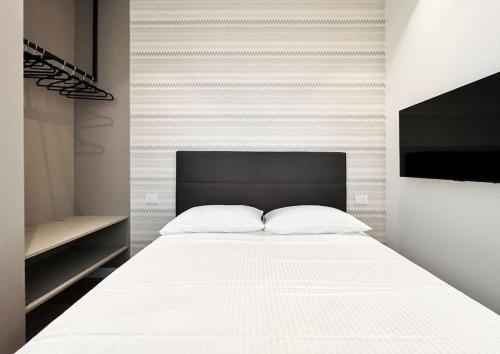 a bedroom with a white bed with a black headboard at YLS Luxury Suites 2 in Milan