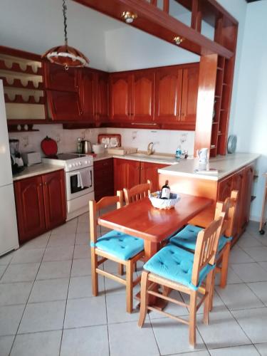 a kitchen with wooden cabinets and a wooden table and chairs at Villa Evmenia Panoramic sea view & Sea front apartments in Skopelos Town