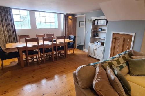 ein Wohnzimmer mit einem Sofa und einem Esstisch in der Unterkunft Holiday Cottage in Snowdonia (Sleeps 10) in Harlech