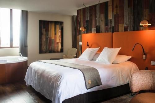a bedroom with a large bed and a bath tub at Le Clos Des Sens in Annecy