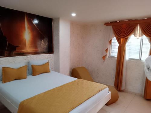 een slaapkamer met een wit bed en een raam bij Hotel el playon in Medellín