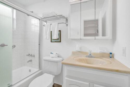 ポンパノビーチにあるWaves Beach Town Studio Apartmentのトイレと洗面台を備えた白いバスルーム