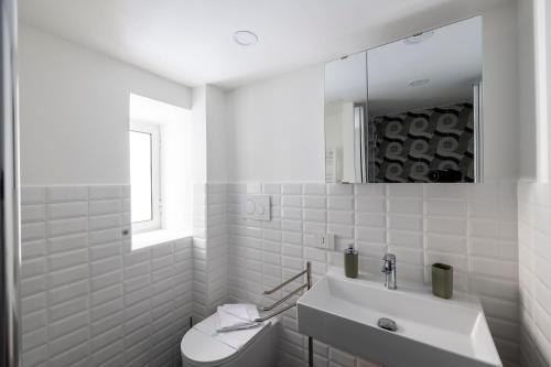 a white bathroom with a sink and a toilet at La Cupola Apartment in Rome