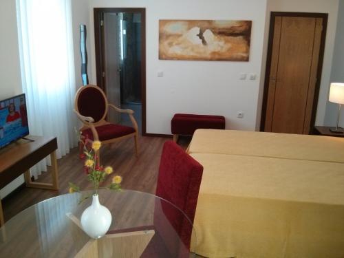 a living room with a table with a vase on it at Solar Guesthouse Olival da Vinha in Castelo de Paiva