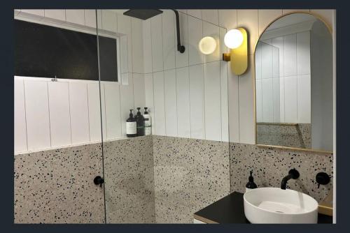 a bathroom with a sink and a mirror at Treetop Retreat Northern Beaches with Stunning Pittwater Bay Views in Newport