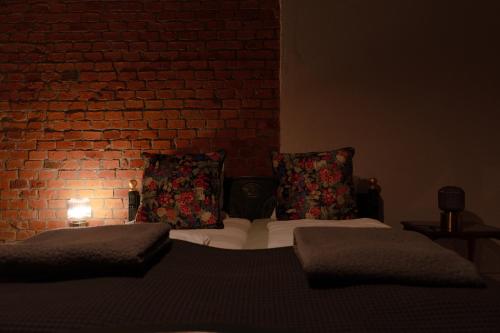 a bedroom with two beds and a brick wall at Uroczysko Oleśnica in Chodzież