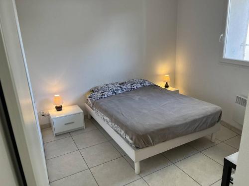 une petite chambre avec un lit et deux tables de nuit dans l'établissement Appartement T3 lumineux avec grande terrasse, clim, parking gratuit et Wi-Fi - 5 personnes - FR-1-770-6, à La Ciotat