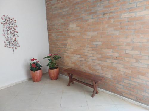 a wooden bench sitting next to a brick wall at Alto padrão !Forno Pizza! Hidro !Vista linda! in Poços de Caldas