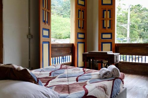 ein Schlafzimmer mit einem Bett mit Handtüchern darauf in der Unterkunft HOSTAL CASA VICTORIA PIJAO in Pijao