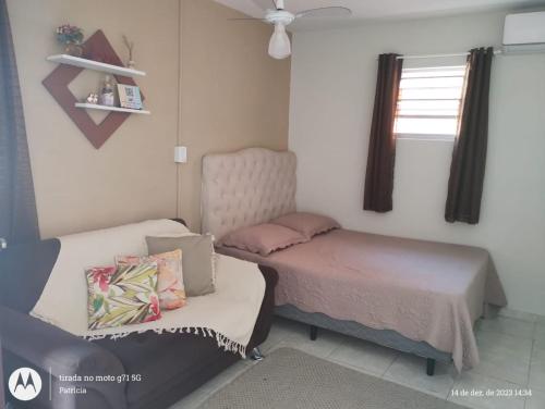 a bedroom with two beds and a window at Kit net para casal in Ubatuba