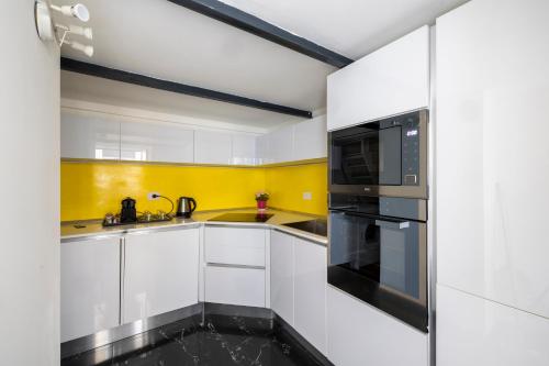 a kitchen with white cabinets and a black oven at La Cupola Apartment in Rome