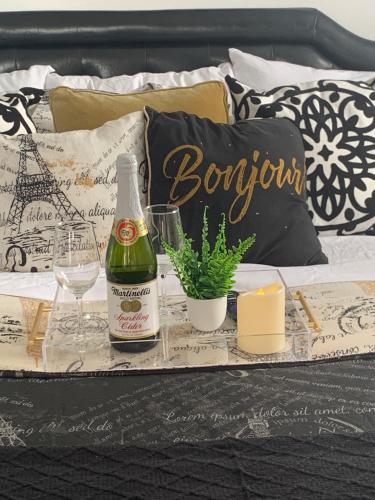 a tray with a bottle of champagne and glasses on a bed at Your Penthouse Ocean view with City lights and Queen Mary too in Long Beach